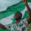 A Nigerian Youth holding the Nigerian Flag in Joy and courage